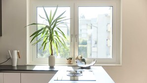 Eine Küche mit Fenster, einer Pflanze und einem kleinen Dekorationsgegenstand auf der Fensterbank.