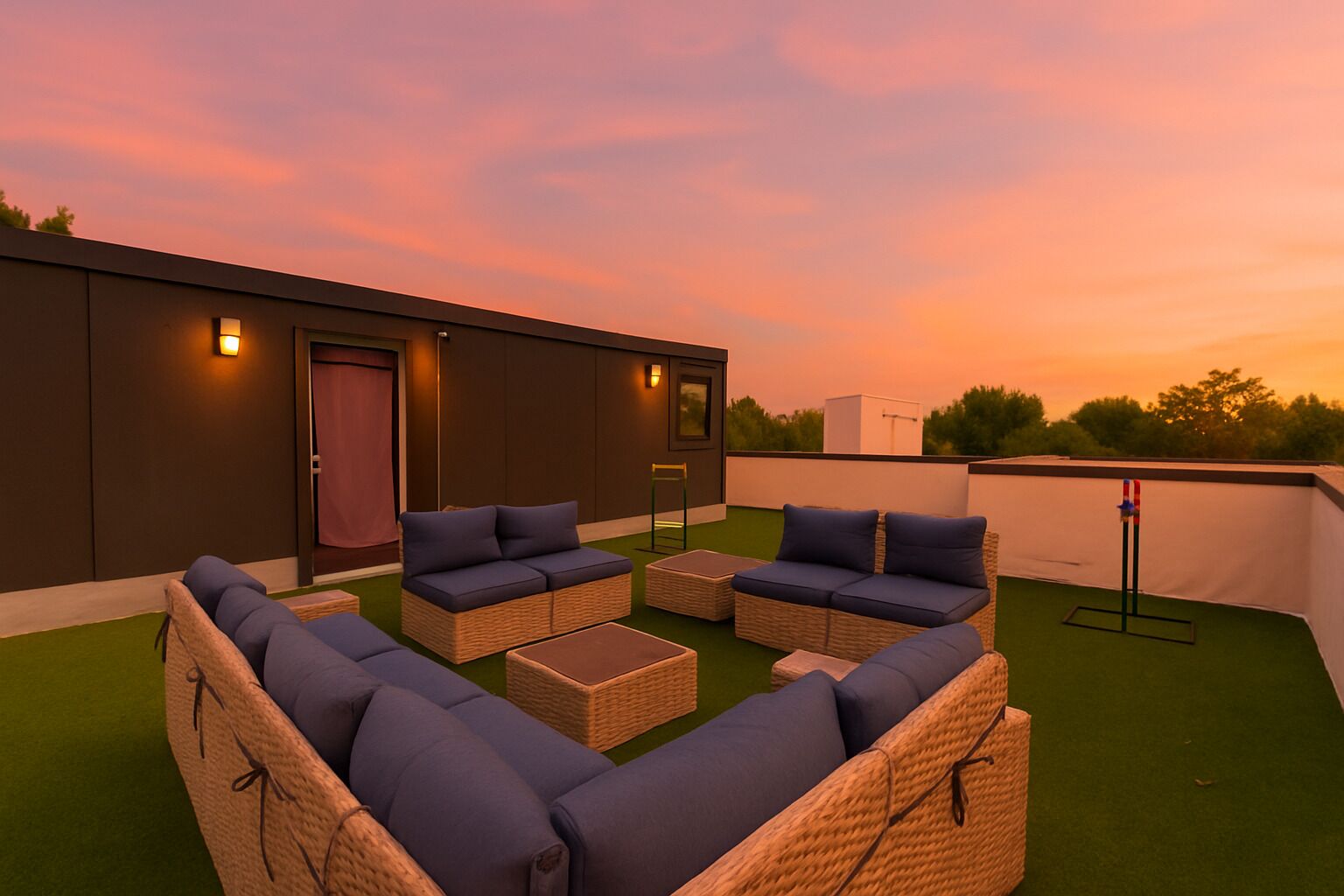 A rooftop terrace with wicker furniture and cushions, a door, and a flagpole.