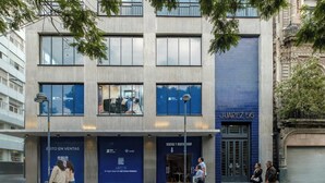 Een modern gebouw met een blauwe gevel, grote ramen en een bord met de tekst 'JUAREZ 56'.