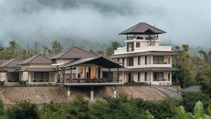 Ein modernes Resort mit mehreren Villen, einem zentralen Turm und einer Mauer aus Stein.
