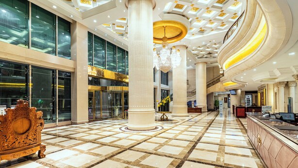 A spacious lobby with a checkered floor, large columns, and a grand chandelier. - Golden Plaza International Hotel (Nanning)