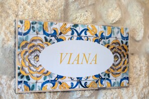 A nameplate with 'VIANA' on a tiled wall.