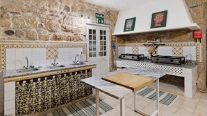 Una cocina con pared de piedra, un fregadero, una estufa y un armario.