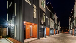 Una fila di edifici moderni dai colori scuri con una strada lastricata in mattoni.