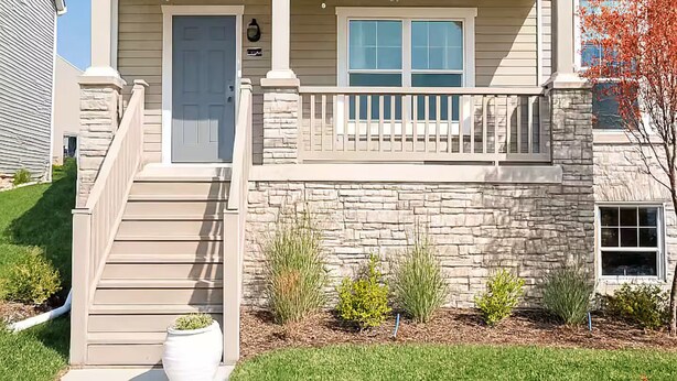 A two-story house with a stone facade, a front porch, and a small garden. - Home-away-from-home, Entire home in West Des Moines, Iowa (West Des Moines)