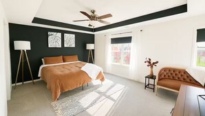 A bedroom with a bed, a chair, a desk, and a ceiling fan. - Home-away-from-home, Entire home in West Des Moines, Iowa (West Des Moines)