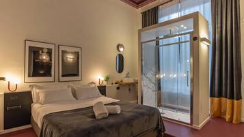 Ein Schlafzimmer mit Bett, Nachttischen, einem Spiegel, einem Fenster mit Vorhängen und einer Duschkabine.