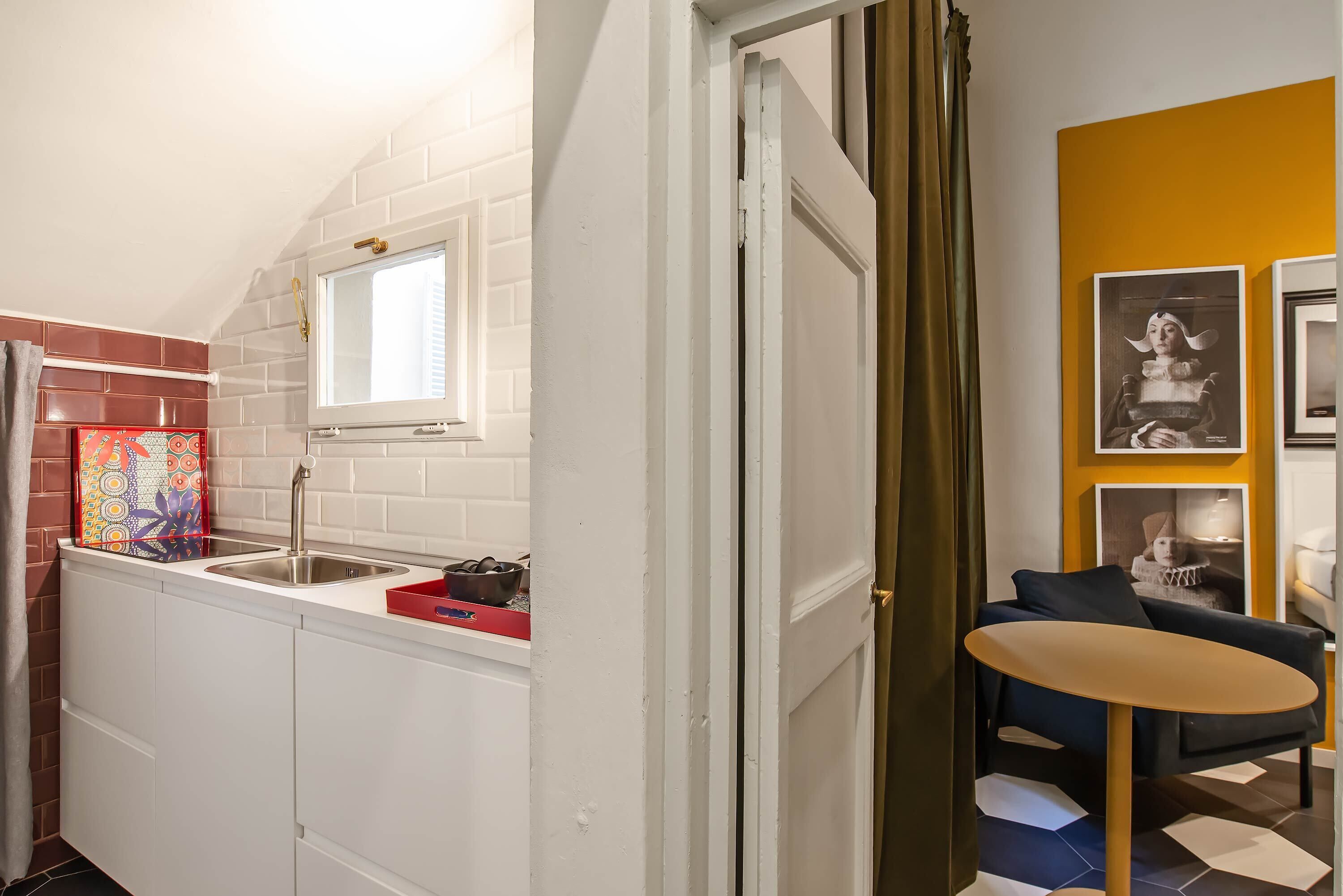 A compact kitchen with a window, a sink, and a small table.