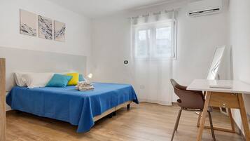 A bedroom with a bed, a desk, and a chair.