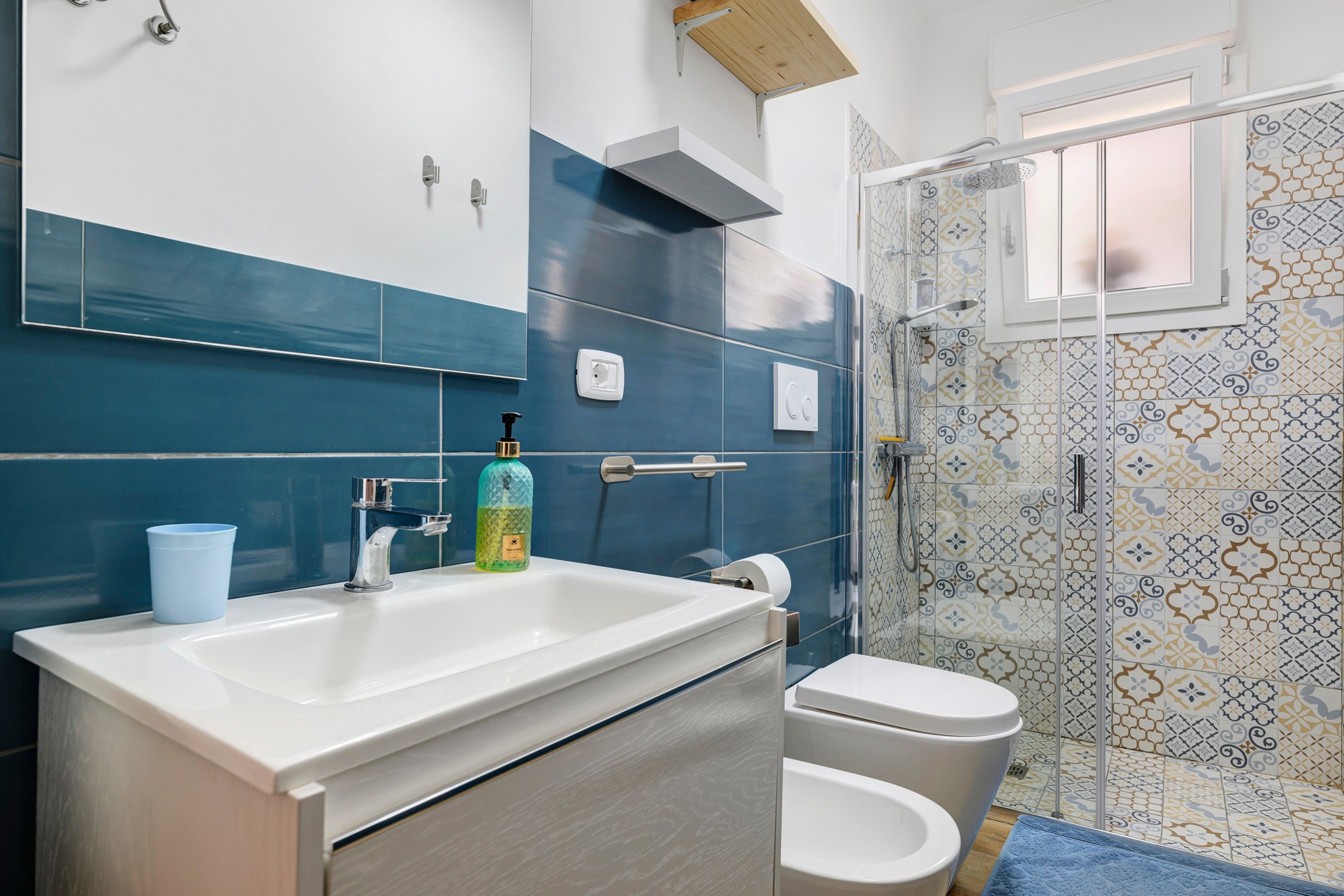 A bathroom with a large sink, toilet, and shower area.