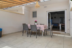 A dining area with a table and chairs, a hanging light fixture, and a view into another room. - Villa Ninfea No.5 with Sea View, Wi-Fi and Air Conditioning 'Residence Pietrantonio' (Marina di Lizzano)