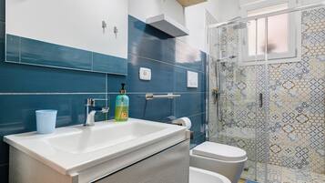 Ein Badezimmer mit großem Waschbecken, Toilette und Duschbereich.