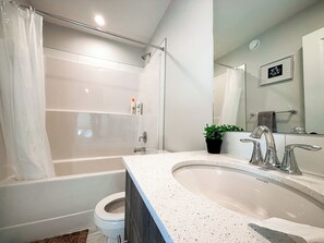 A modern bathroom with a bathtub, toilet, and sink. - 3 bedroom + office full house in the heart of Southfork Leduc (Leduc)