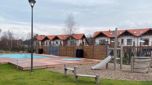 Ein Wohngebiet mit Schwimmbad, Rutsche und Holzterrasse.
