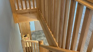 Eine Holztreppe mit Blick auf ein Schlafzimmer darüber.