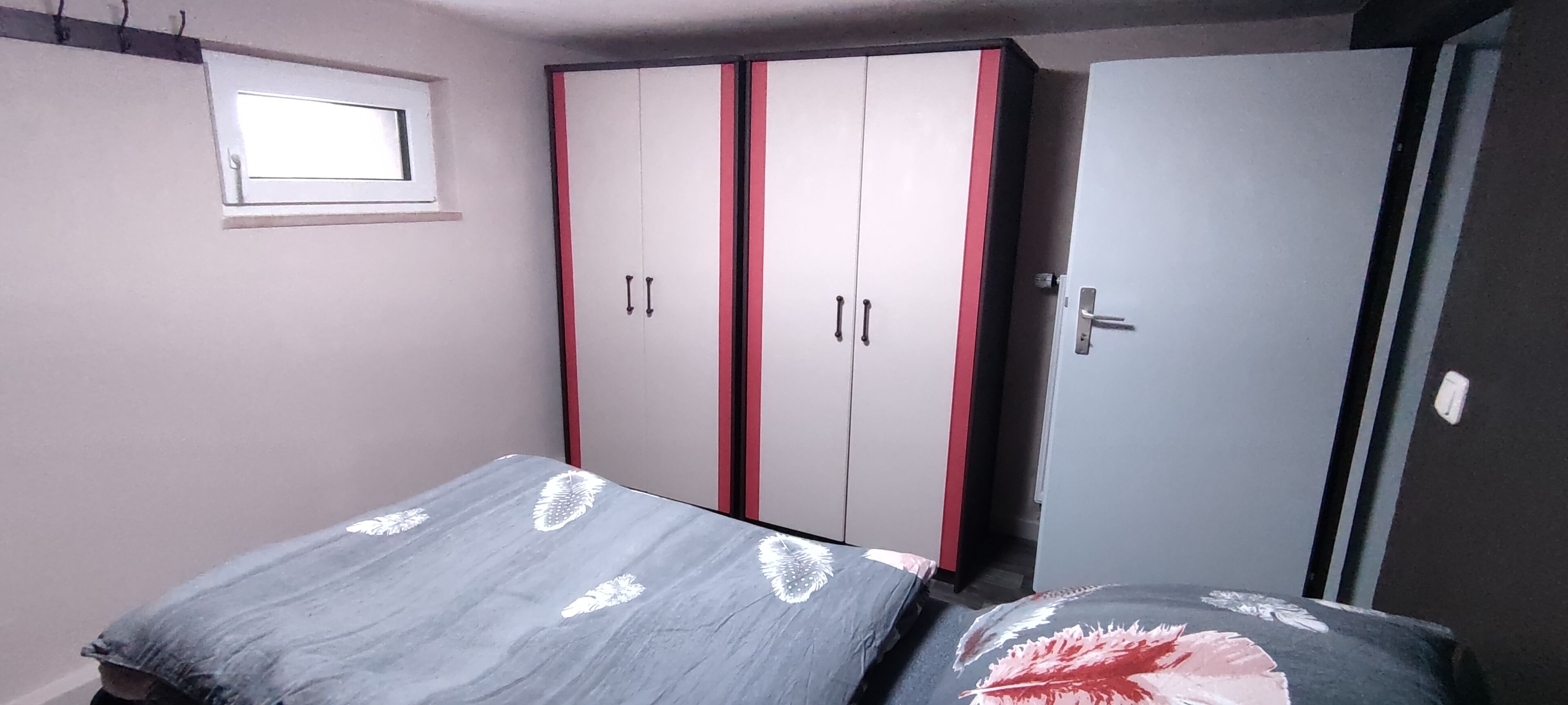 Ein Schlafzimmer mit einem Bett, einem Kleiderschrank und einer Tür.