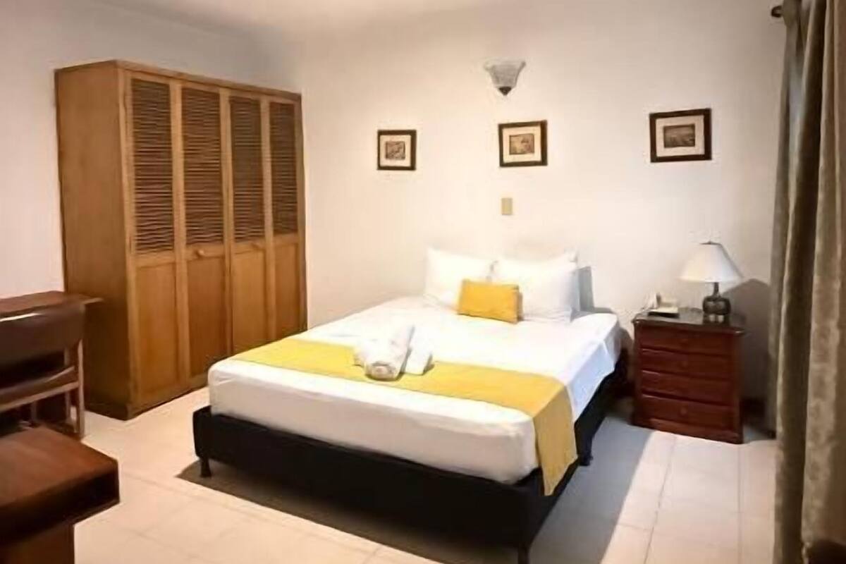 Une chambre à coucher comprenant un lit, une armoire, une table de chevet et une lampe.