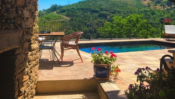 A stone archway leading to a patio with a pool, outdoor furniture, and a view of a green hillside. - Ciucciarella Apartment in Casa Ghjunca Guesthouse (Rapale)