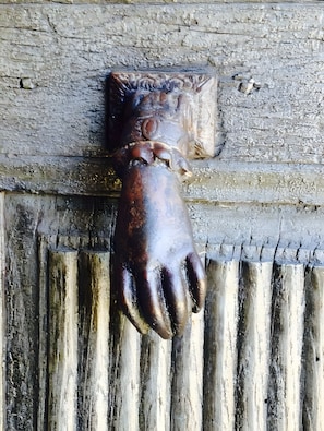 A rustic wooden door with a carved animal head.