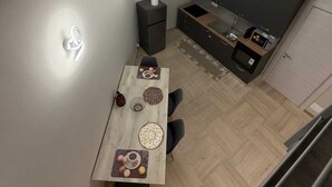 A modern kitchen with a dining area, a built-in oven, and a flat-screen TV. - Dante Urbano Loft (Torino)