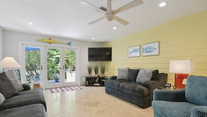 A living room with a sofa, two armchairs, a television, and a ceiling fan. - Beautifully renovated Longboat Key Villa brief walk to a private beach (Longboat Key)