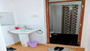 Ein Badezimmer mit Waschbecken, Toilette und Duschbereich.