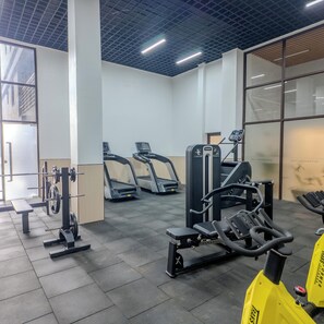 A gym with treadmills, weight machines, and a bench. - 3-bedroom apartment in Westlands with great amenities and central location (Nairobi)