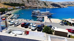 A marina with boats, a dock, and a parking area with cars. - Seafront Apartment Valla 5 (Novalja)