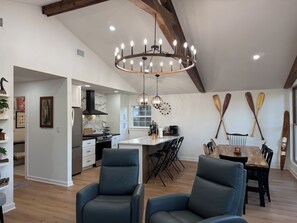 A spacious kitchen with modern appliances, a dining area with a wooden table, and a living space with a large window. - Amazing fully updated Lake Catherine Rustic Elegant group or family escape place (Hot Springs)
