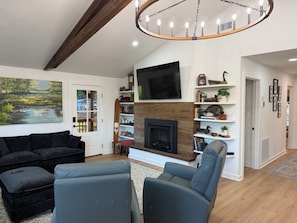 A living room with a fireplace, a mounted TV, and a large painting. - Amazing fully updated Lake Catherine Rustic Elegant group or family escape place (Hot Springs)