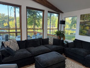 A living room with a sectional sofa, a coffee table, and a view of a deck and lake. - Amazing fully updated Lake Catherine Rustic Elegant group or family escape place (Hot Springs)