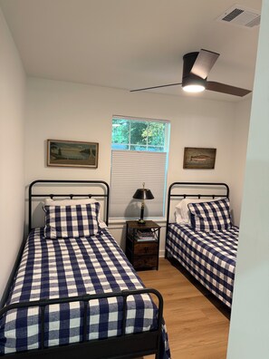 A bedroom with two beds, a window with blinds, a ceiling fan, and artwork on the walls. - Amazing fully updated Lake Catherine Rustic Elegant group or family escape place (Hot Springs)