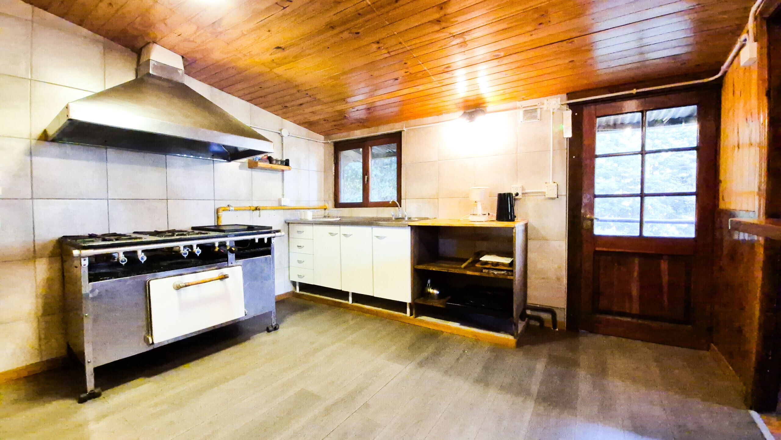 A kitchen with a stove, cabinets, and a window.