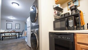 A compact kitchen with a washing machine, a dishwasher, a microwave, and a coffee maker. - Full clean 3-bedroom house close to stadiums and pet friendly! (Grandview)