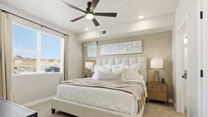 A bedroom with a bed, bedside tables, a ceiling fan, and a window with curtains. - Sand Yeti Brand New Listing! (Hurricane)