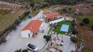 Ein Anwesen mit befestigter Auffahrt, einem Schwimmbad und einer kleinen Gartenanlage.