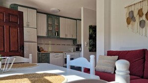 A cozy living room with a red sofa and a white dining table with a placemat. - Mirador de Picos Apartment (Pido)