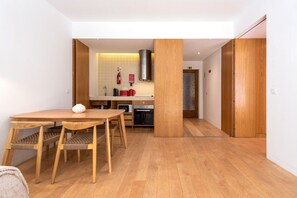 A modern kitchen with wooden cabinets, a microwave, and a stove. - Garça Real - Porto Retreat by Lisbeyond (Porto)