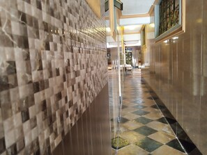 Un pasillo con pared de azulejos y suelo a cuadros.
