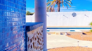 A building with a tiled facade and a palm tree in the background. - Villa bleu azur 💙 (Djerba)