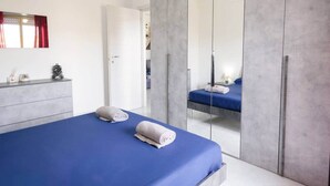 Un dormitorio moderno con una cama grande, un aparador y un espejo.