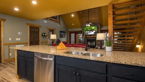 A kitchen with granite countertops, a stainless steel dishwasher, and wooden cabinetry. - A Time for Us (Gatlinburg)