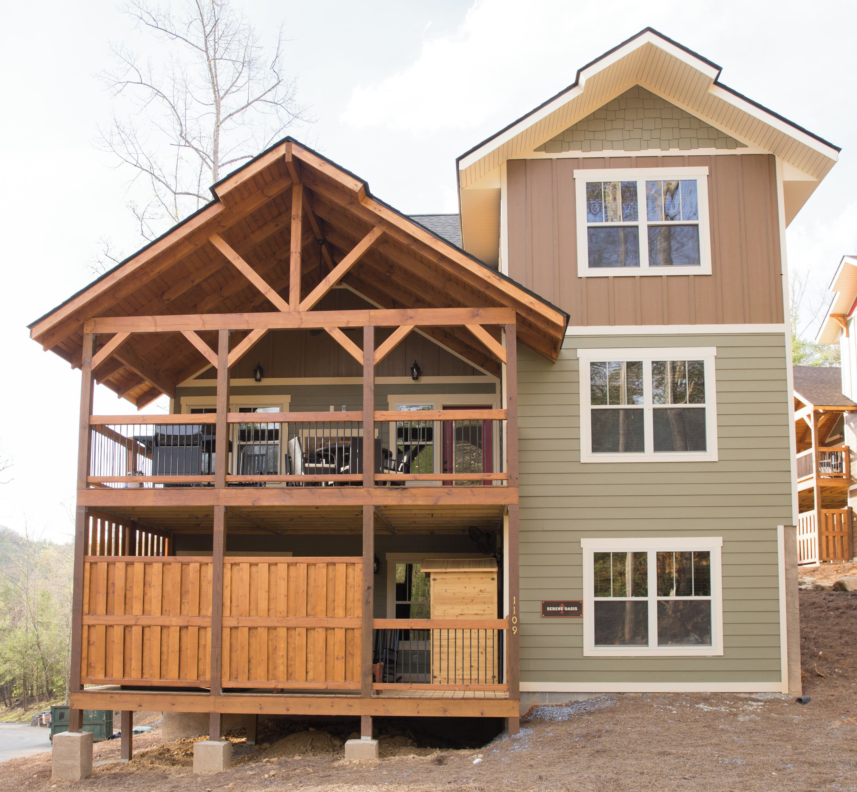 A two-story building with a wooden deck and a covered porch.