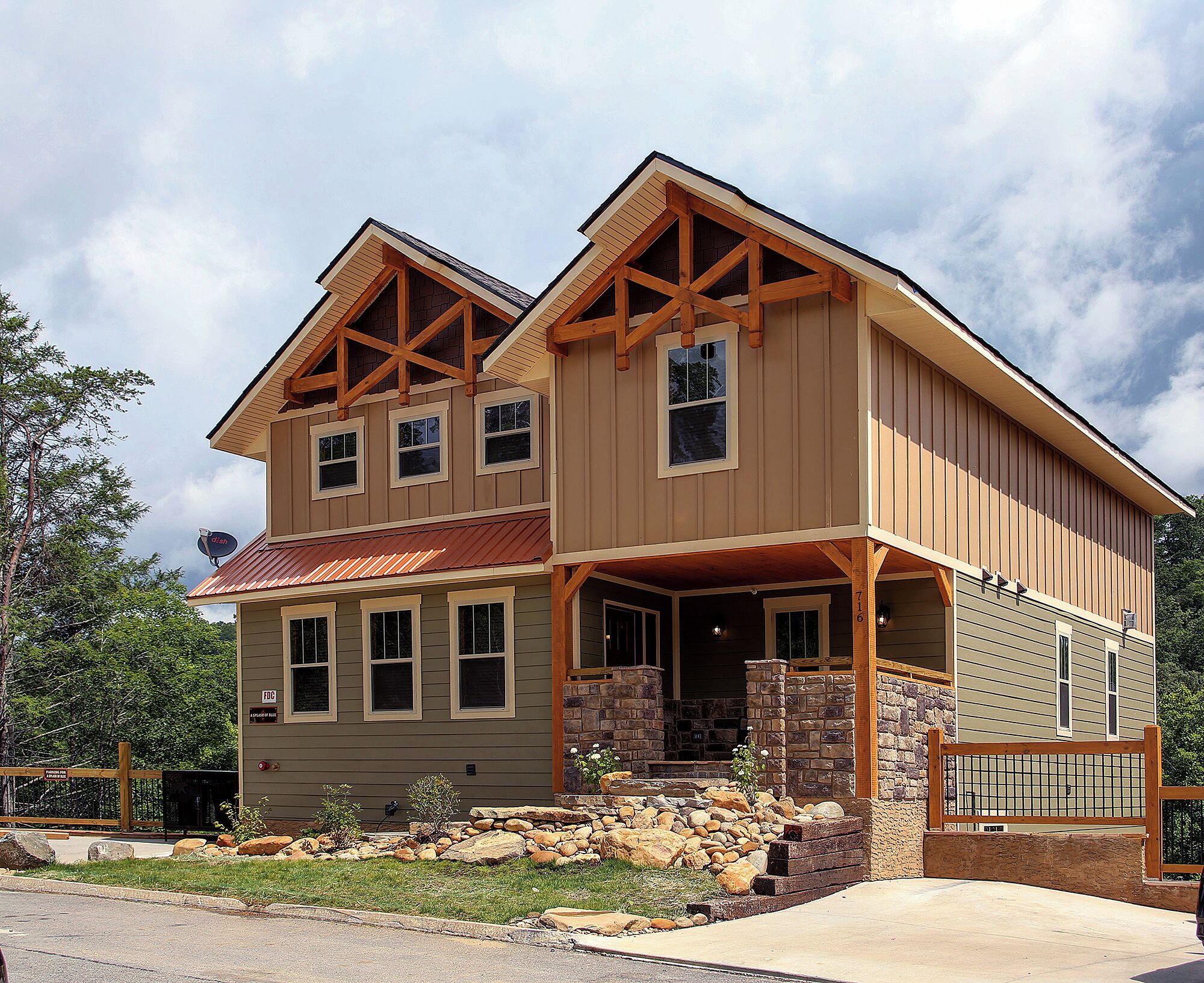 A two-story house with a stone foundation, wooden beams, and a metal roof.