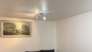 A modern living room with a sectional sofa, a glass coffee table, and a ceiling fan. - Apparently 2 rooms (Vaulx-en-Velin)