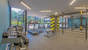 Un gimnasio con cintas de correr, mancuernas y máquinas de pesas.