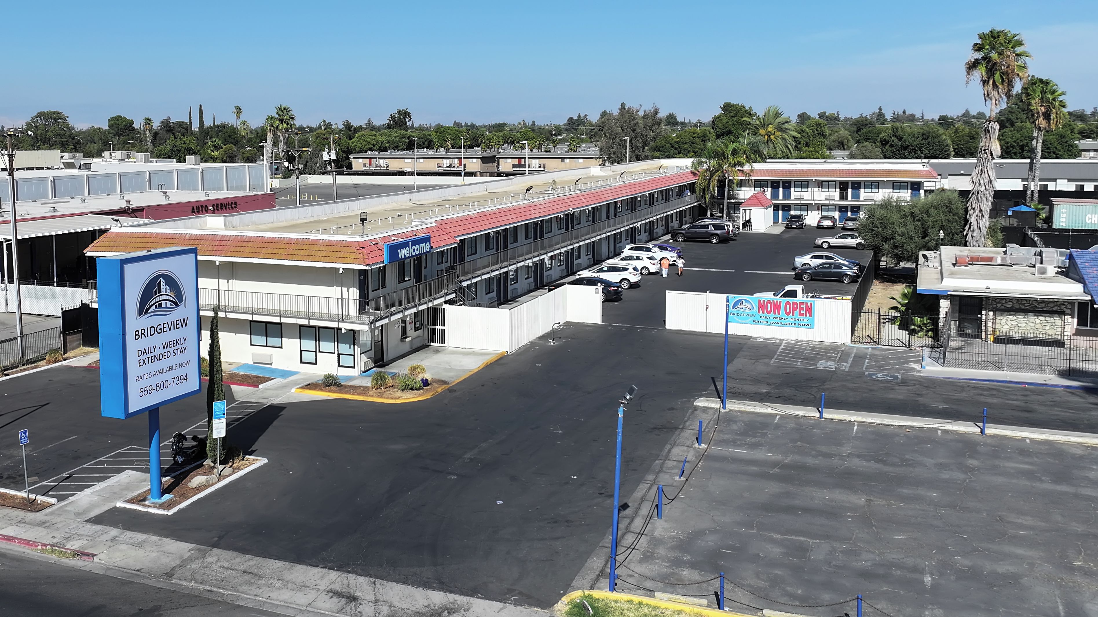 A parking lot with a building labeled 'Bridgeview' and a sign indicating 'NOW OPEN.'