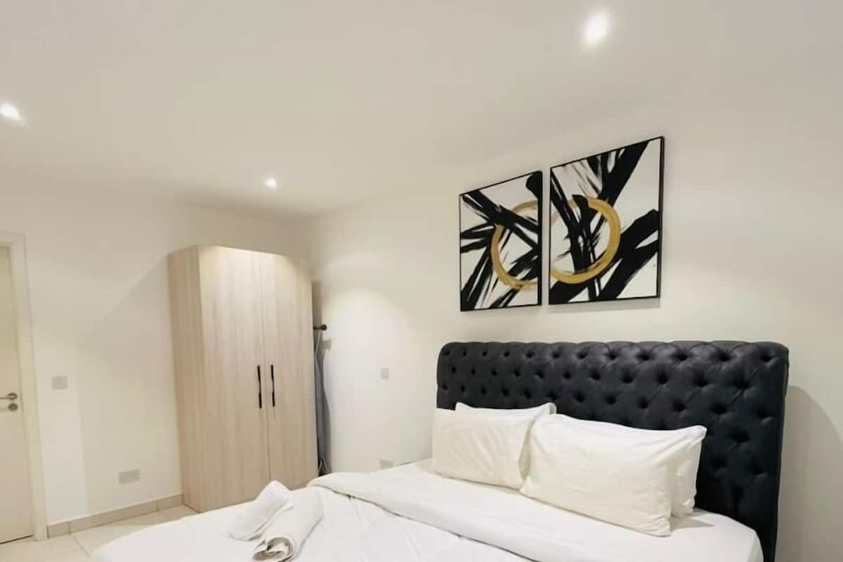 Un dormitorio con cama, armario y arte abstracto en la pared.