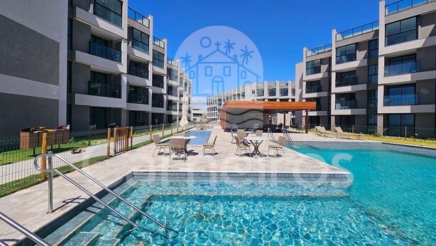 A modern hotel with a swimming pool, outdoor seating, and a clear blue sky. - Flats Garden no Nomar Carneiros Ecoloving (Tamandaré)