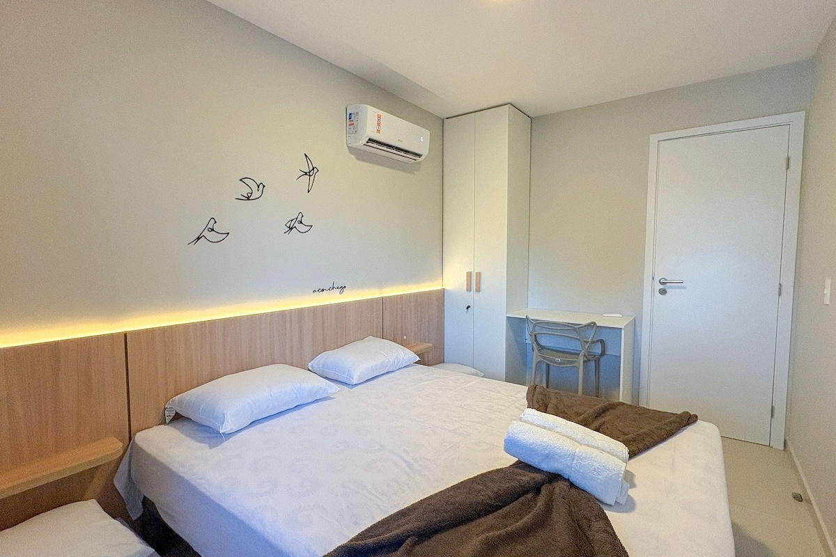 Ein Hotelzimmer mit Bett, Nachttisch und Spiegel.